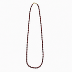 Lea Garnet necklace, a long single strand of deep red natural stone beads with a gold-plated clasp