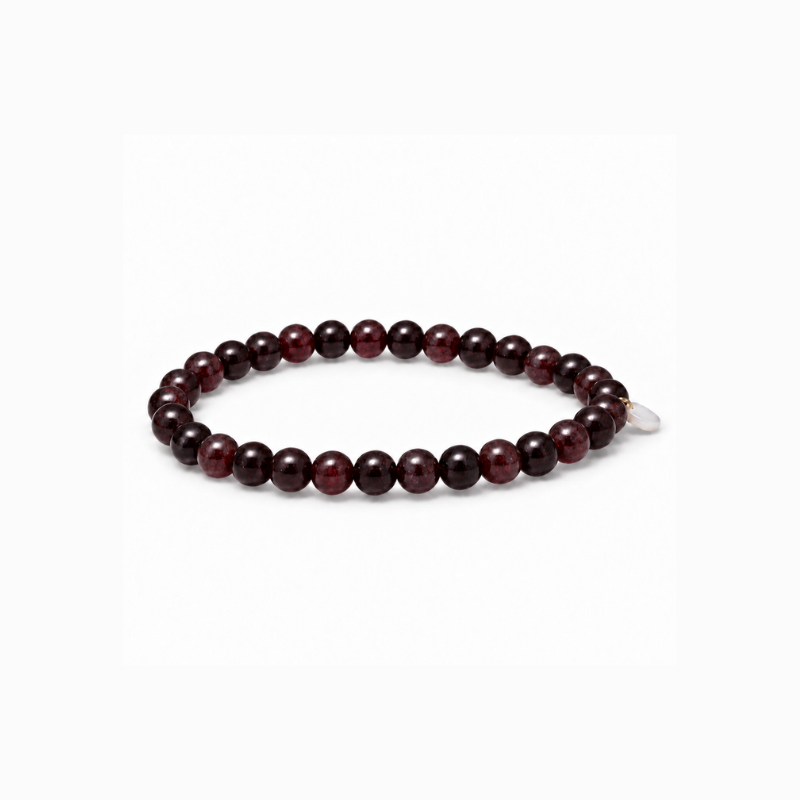 Essential Garnet stretch bracelet with deep wine-red natural stone beads and a small mother-of-pearl accent