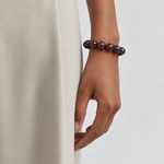 Chunky Garnet bracelet worn on the wrist, styled with a cream skirt