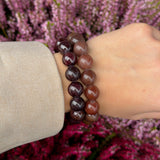 Chunky Garnet bracelet stacked with a second garnet bracelet on the wrist against purple heather