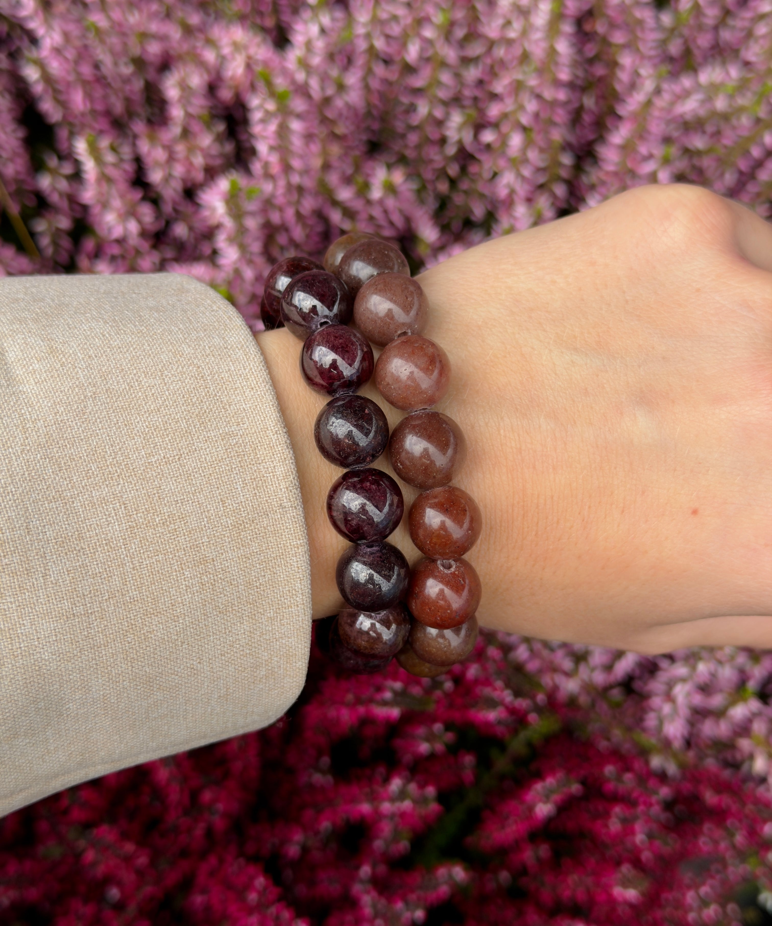 Chunky Garnet bracelet stacked with a second garnet bracelet on the wrist against purple heather