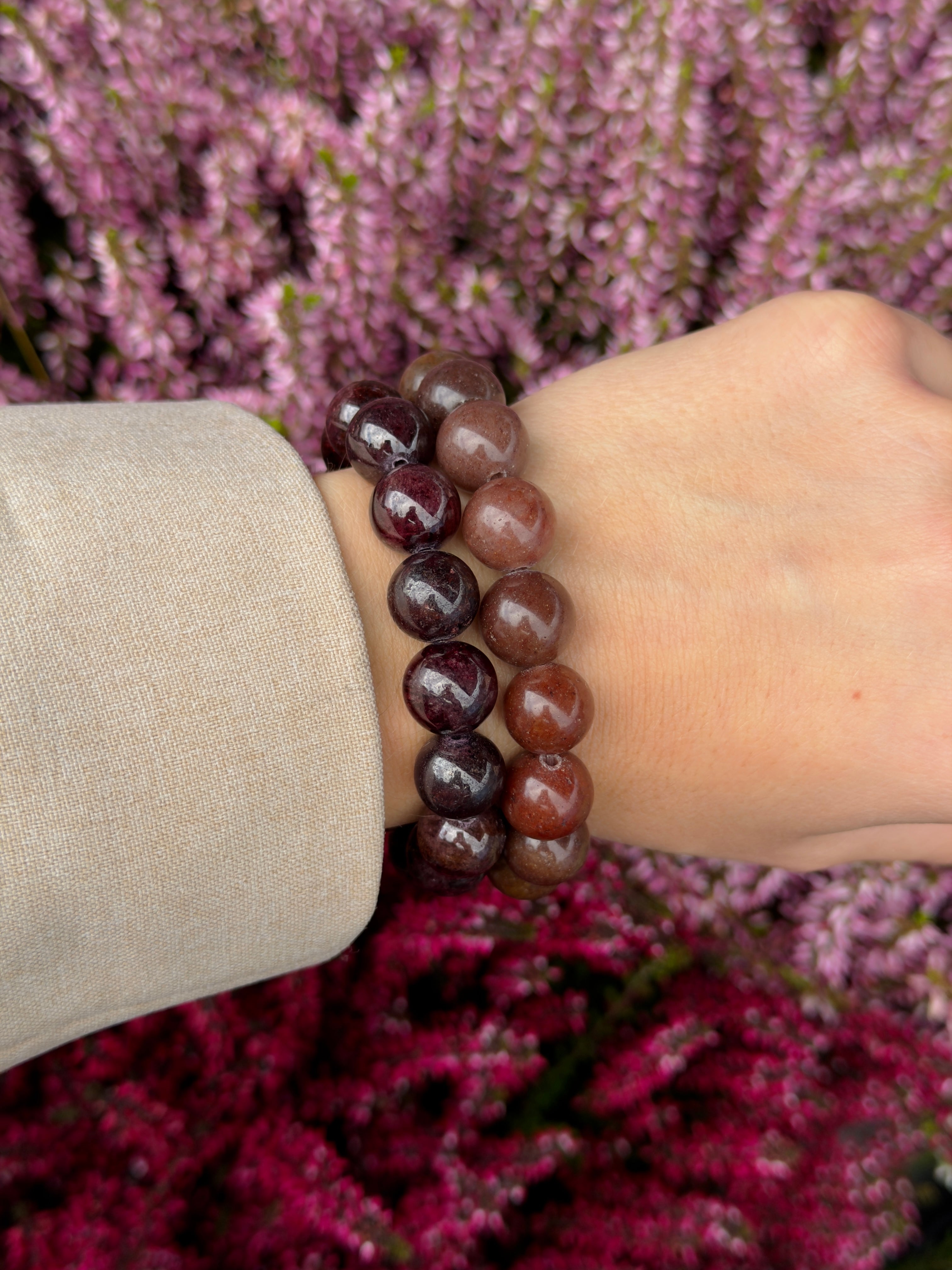 Chunky Garnet bracelet stacked with a second garnet bracelet on the wrist against purple heather