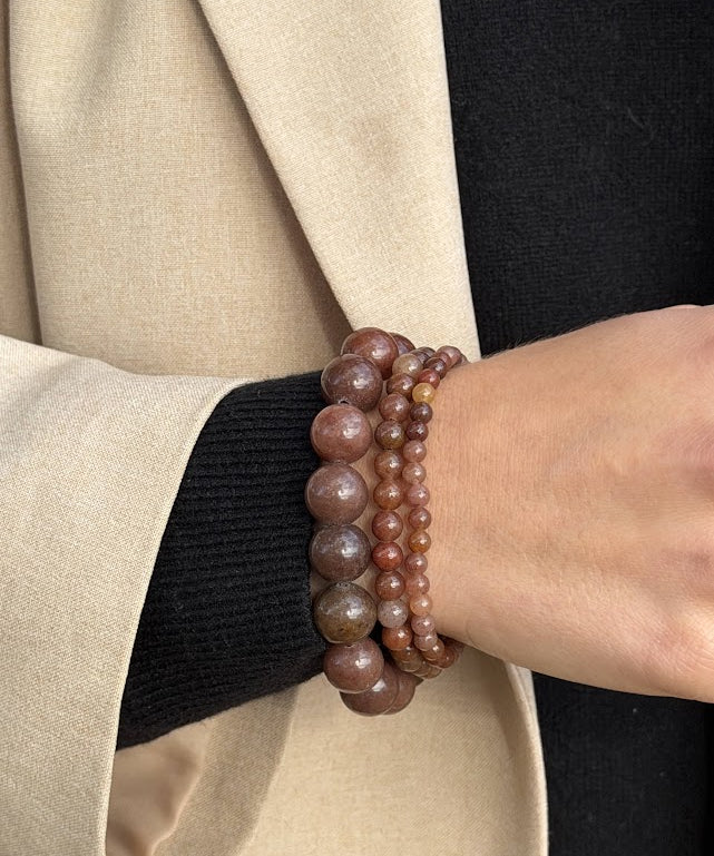 Essential Purple Brown Aventurine bracelet worn in a three-bracelet stack with a black knit and beige blazer