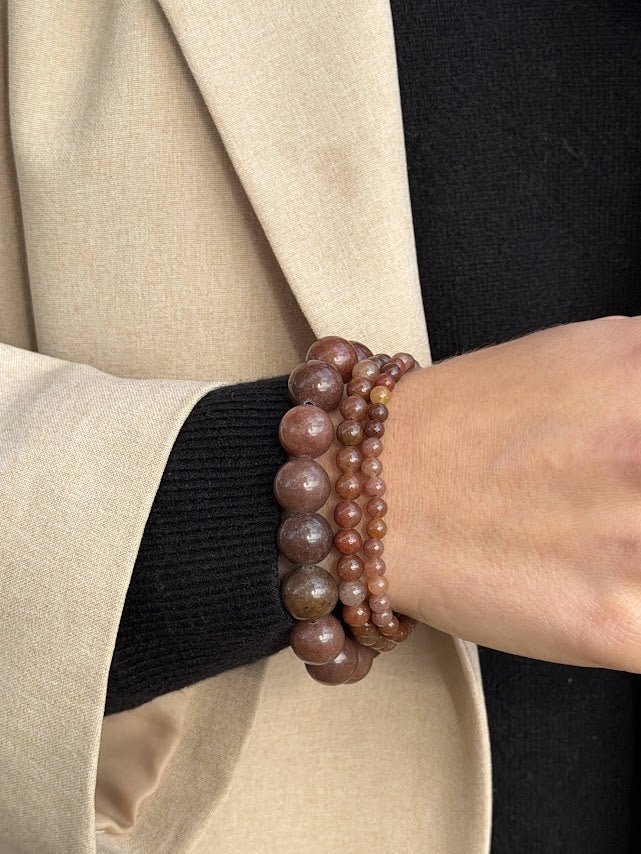 Essential Purple Brown Aventurine bracelet worn in a three-bracelet stack with a black knit and beige blazer