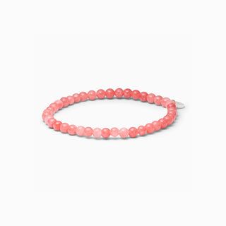 Petite Redstone Quartz stretch bracelet with small coral-pink natural stone beads, on a white background
